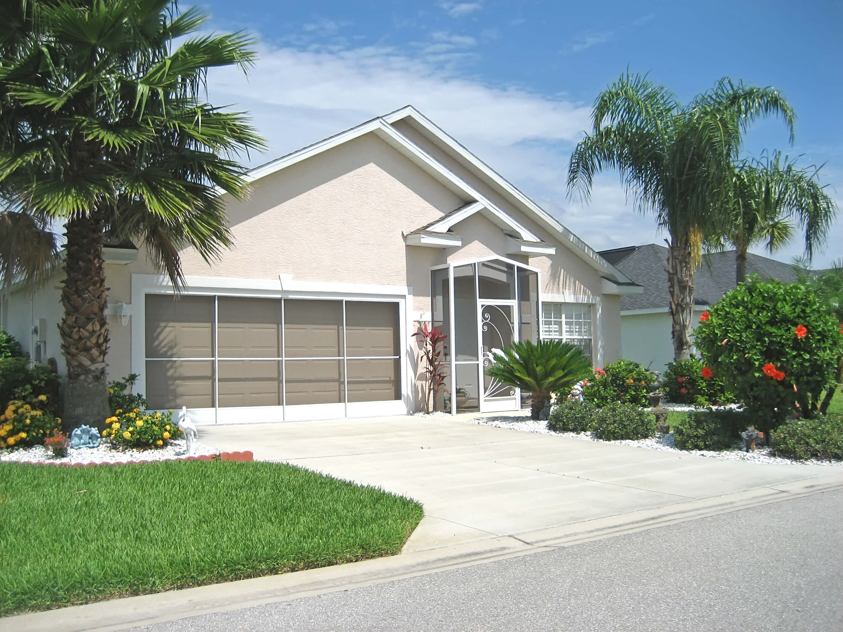 Florida home with palm trees and well-kept landscaping, representing insurance discounts available for features like wind mitigation, protective devices, and secure construction.
