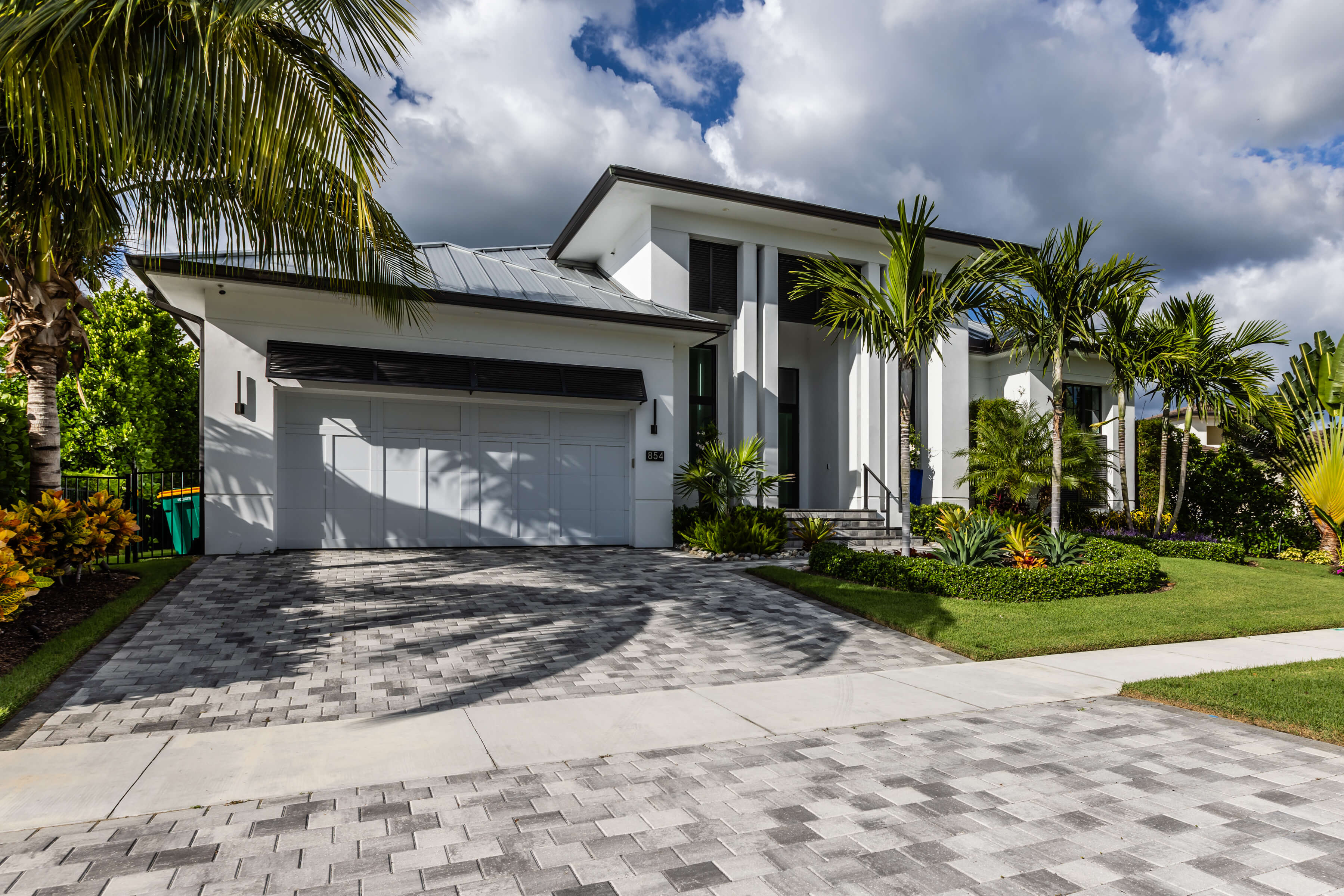 Modern luxury Florida home with palm trees and landscaped yard, representing the need for specialized insurance coverage for high value homes
